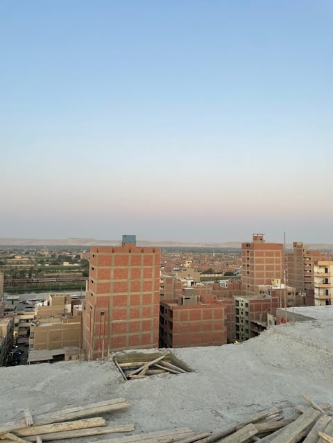 Aerial view of an urban development site with red brick buildings under construction in a desert landscape